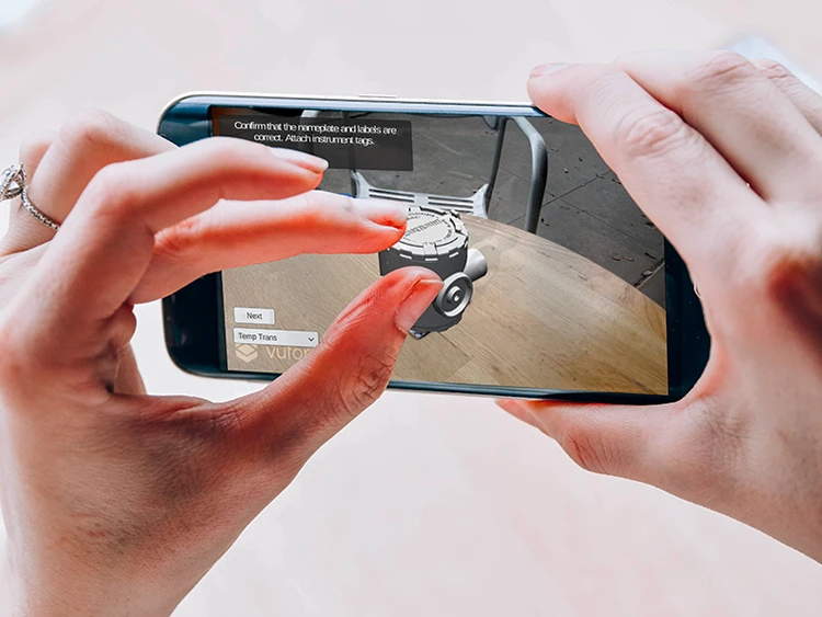 Augmented reality app on a smartphone overlaying live data and instrument tags onto industrial equipment