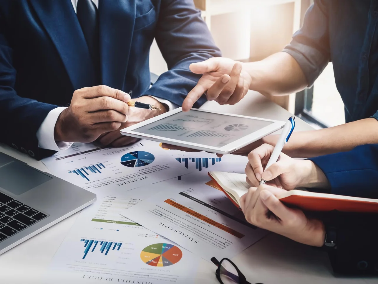 Business analysts and consultants reviewing charts and discussing project requirements at a table