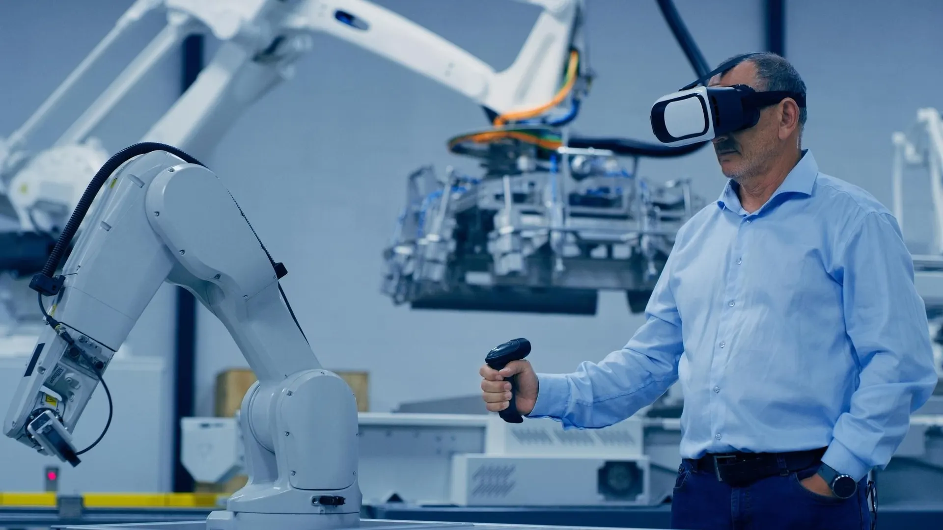 Engineer in a VR headset operating an industrial robotic arm