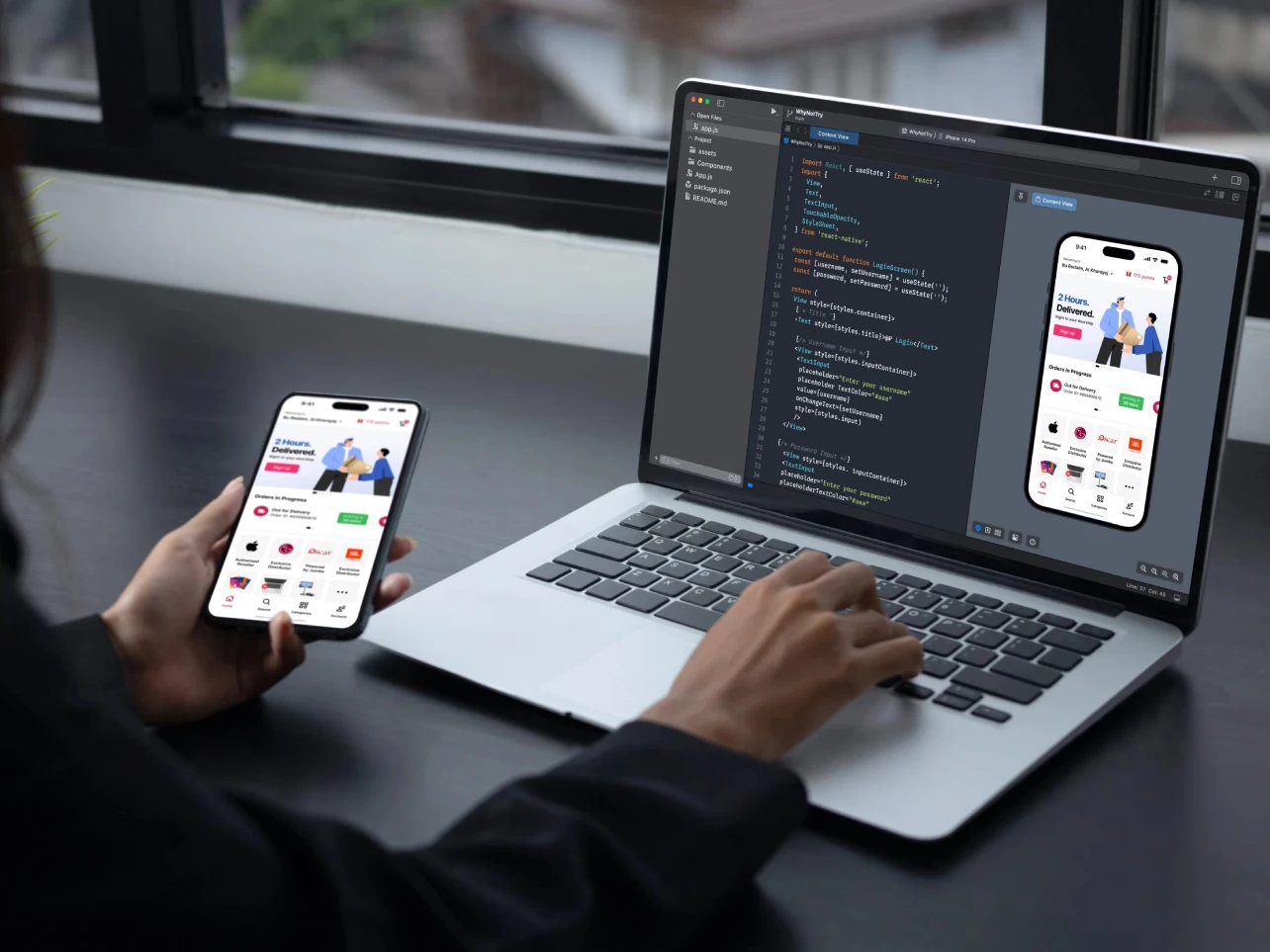 Developer working on mobile app development using a laptop and smartphone
