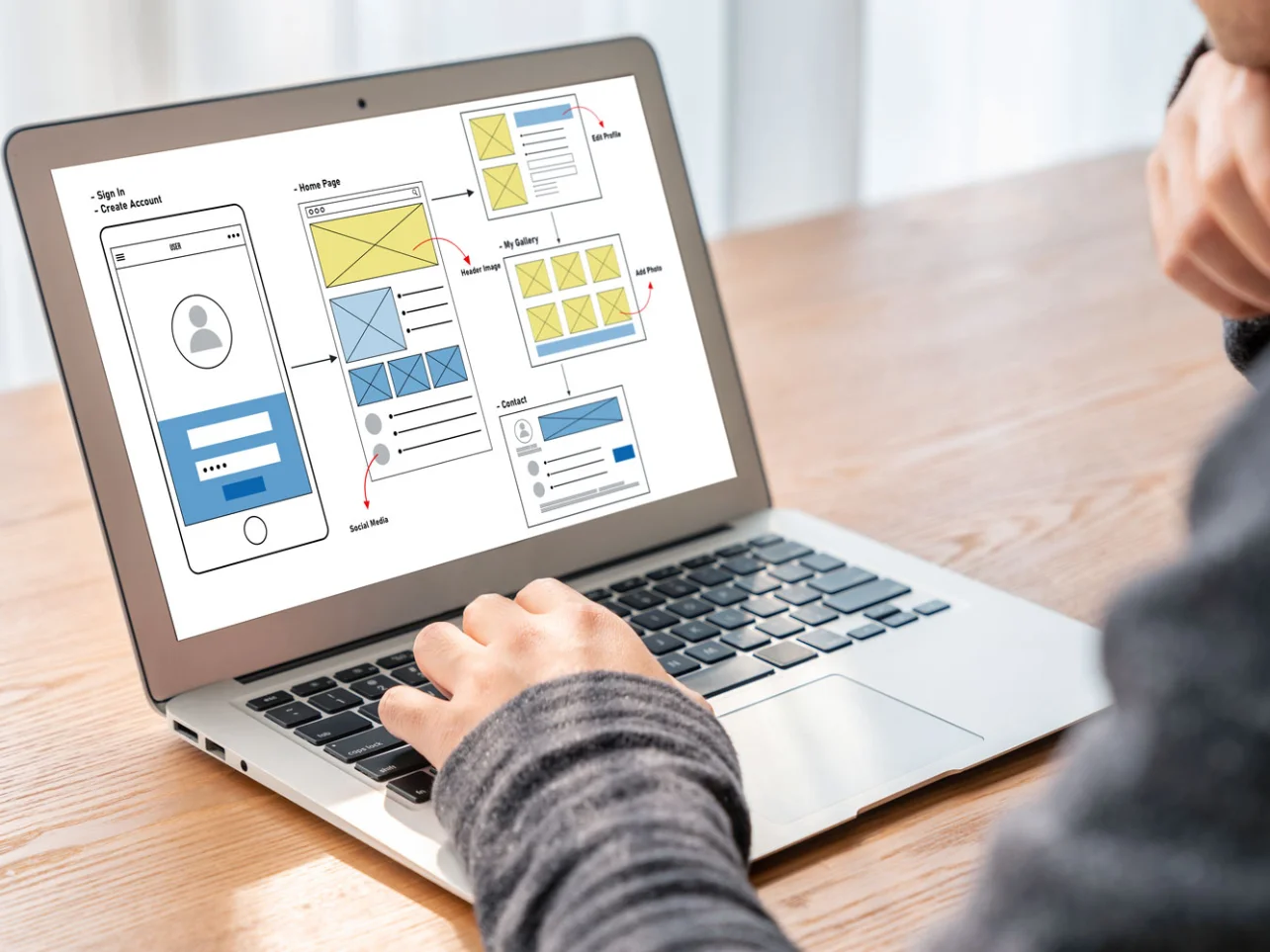 MVP development specialist creating wireframes and user flows for a digital product on a laptop