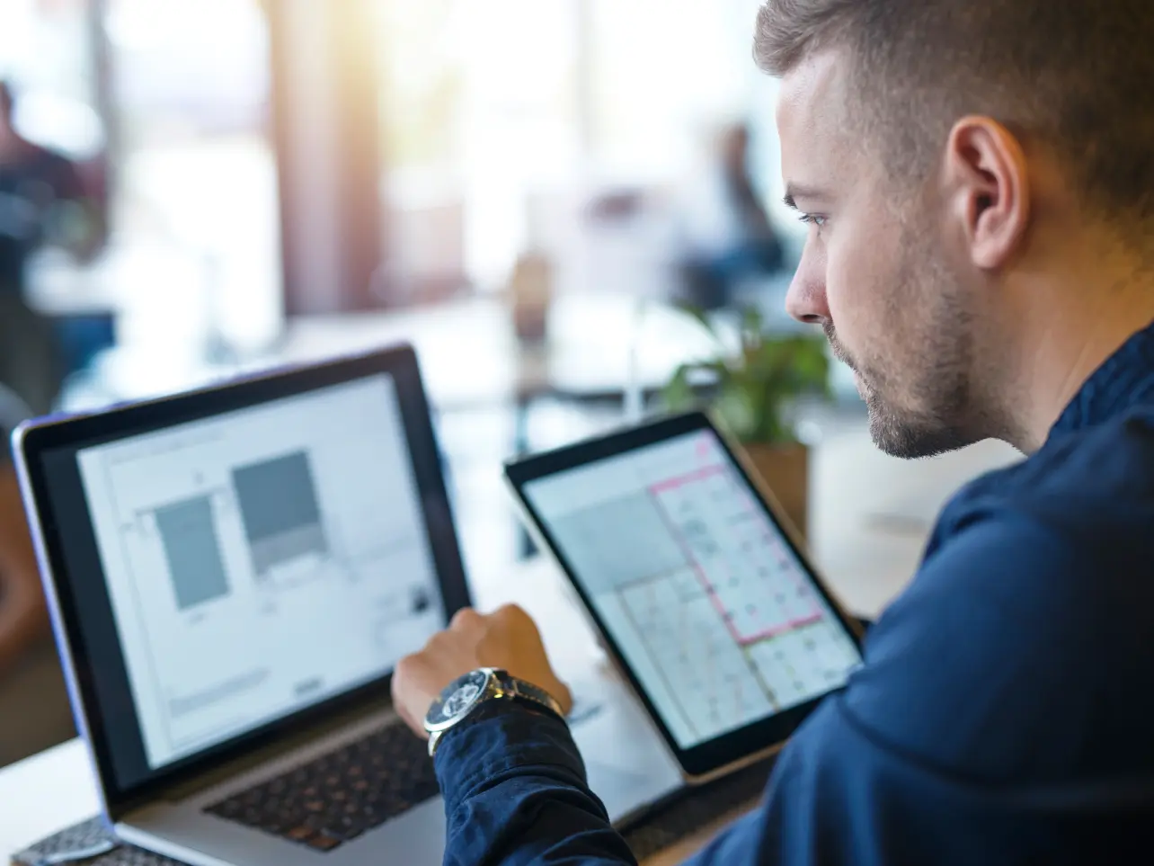 Solution integration specialist working with software interfaces across a laptop and tablet